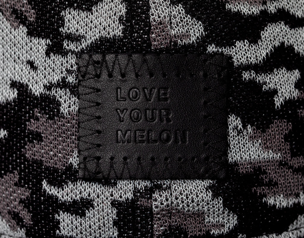 Close-up of patch on black camo cap